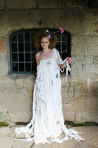 woman in white one-shoulder butterfly print floor-length dress standing in front of window during daytime thumbnail