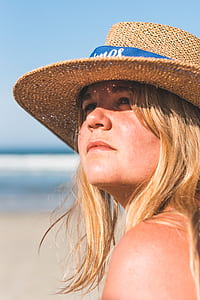 close-up photo of woman wearing brown wicker sun hat near beach during daytime thumbnail