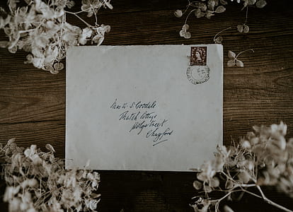 white printed envelope on brown wooden table thumbnail