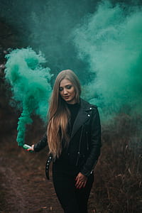 woman wearing green jacket holding green bottle with smoke thumbnail