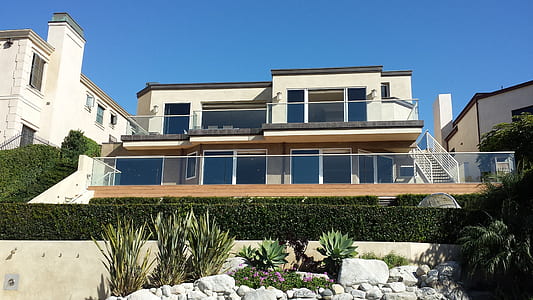 white 2-storey building behind green hedge during daytime thumbnail