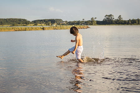 boy playing on body of water thumbnail