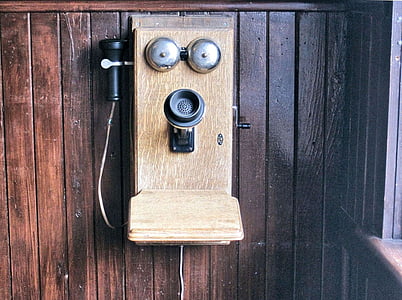 vintage brown and black telephone on brown wooden wall thumbnail