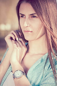 woman in blue top wearing round silver-colored analog watch with link bracelet thumbnail