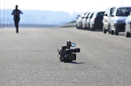 black shoulder mount video camera on road thumbnail