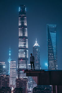 man standing on top of building during nighttime thumbnail