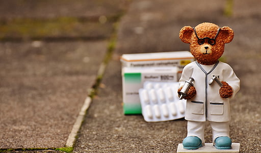 brown doctor bear figurine on selective focus photo thumbnail