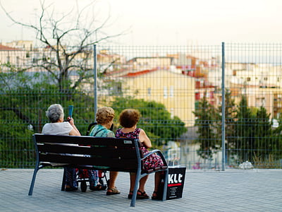 three women sitting on bench looking at trees thumbnail