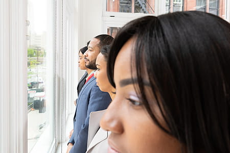Group Of People Lining Up Near Glass Window thumbnail
