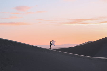 silhouette of person standing on dessert during sunset thumbnail