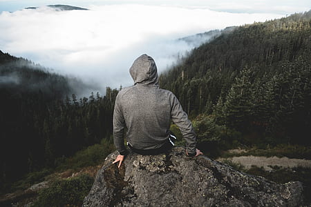 man sitting on rock at the mountain during daytime thumbnail