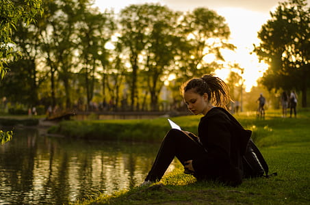 woman sitting beside body of water thumbnail