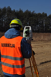 man in front of white and green theodolite thumbnail