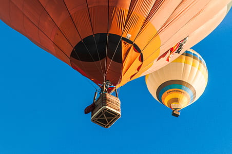 two orange hot air balloons up in the sky thumbnail