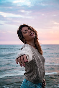 selective focus photography of woman standing near sea thumbnail