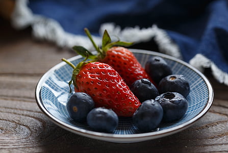 two red strawberries on blue ceramic saucer thumbnail