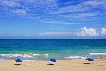 three blue beach umbrellas on seashore under clearsky during daytime thumbnail