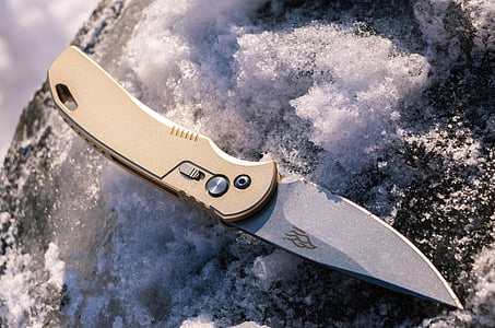 brass-colored handle gray knife on snow thumbnail