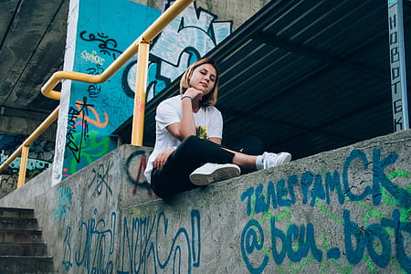 woman sitting on street wall thumbnail