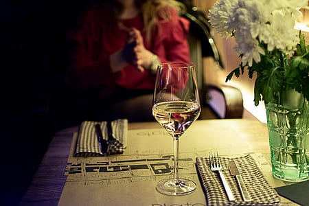 clear wine glass on table beside dining utensils thumbnail
