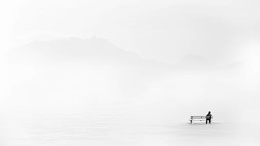 landscape photography of person sitting on white bench thumbnail