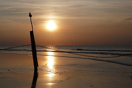 silhouette photography of black stand on seashore thumbnail