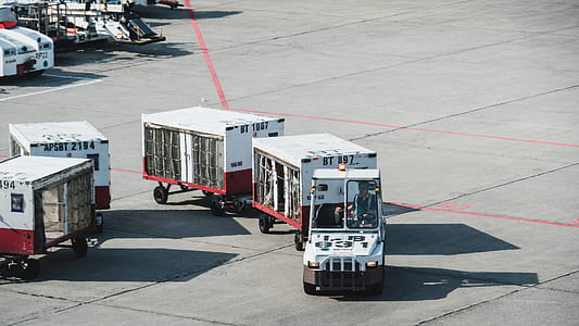 white and red airport luggage trucks thumbnail