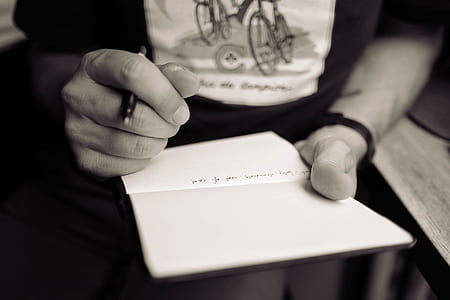 person holding pen and notebook thumbnail
