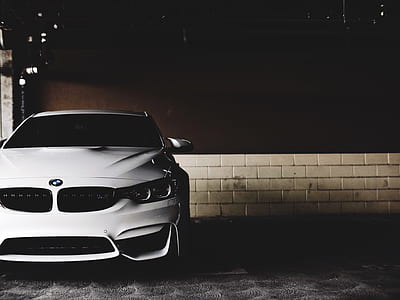 white BMW car parked near white painted wall thumbnail
