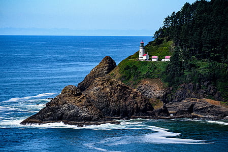 lighthouse beside body of water during daytime thumbnail