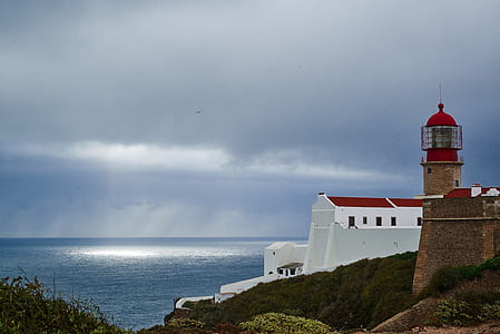 aerial view of lighthouse near body of water thumbnail