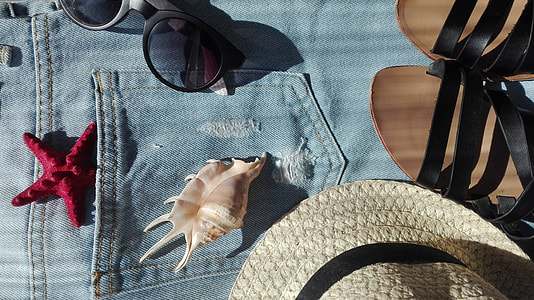 sconce shell beside straw hat and black sandals on denim apparel thumbnail