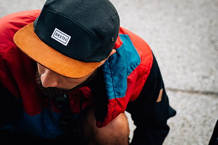 man wearing 5-panel cap walking on street outdoors thumbnail