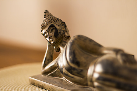 selective focus photography of leaning Gautama Buddha figurine thumbnail