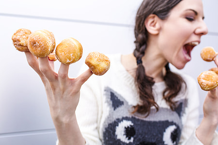 woman wearing white shirt with bake food in her fingers thumbnail