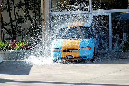 blue and yellow car in car wash during daytime thumbnail