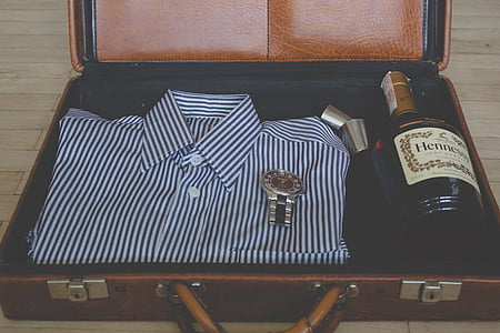 striped collared shirt and liquor bottle in suitcase thumbnail