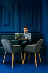 Photo of Man Using Laptop Sitting on Green Sofa thumbnail
