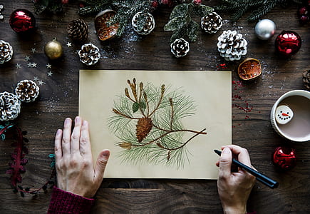 person holding painting on pine cone thumbnail