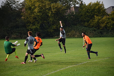 five men playing soccer during daytime thumbnail