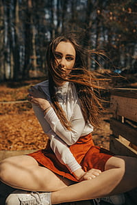 selective focus photography of woman sitting beside wooden crate thumbnail