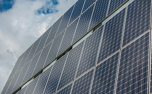 solar panel array under cloudy sky thumbnail