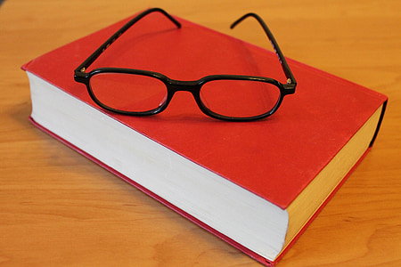 black framed eyeglasses on red closed book thumbnail