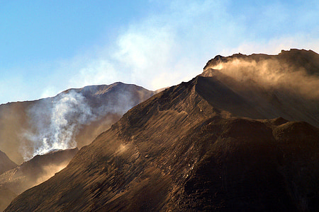 landscape photography of black mountain with smokes thumbnail