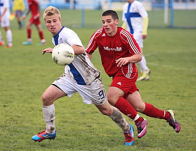 two men playing soccer on field thumbnail
