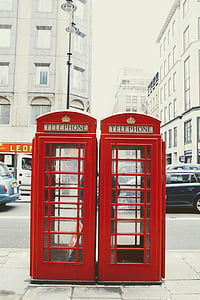 two vintage red telephone booths beside sidewalk thumbnail