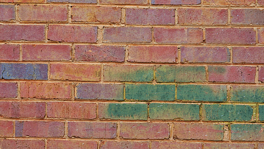 red concrete brick wall with green and purple paint thumbnail