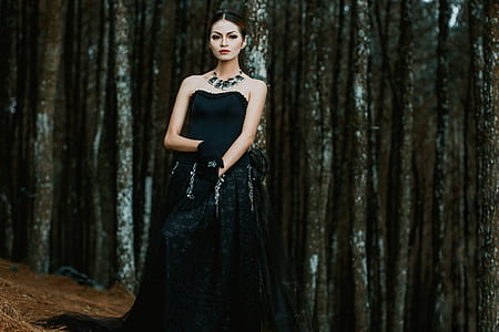 woman wearing black tube long dress standing on forestr thumbnail
