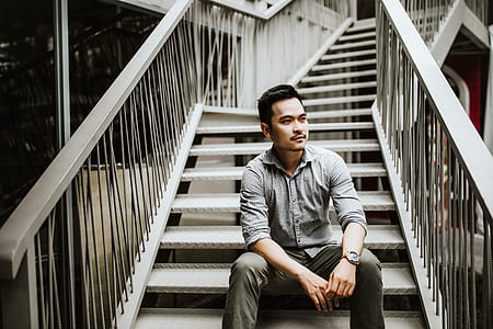man sitting of white stairs thumbnail