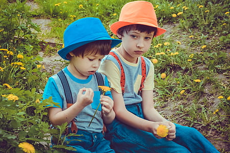 two boys wearing blue and orange hats thumbnail